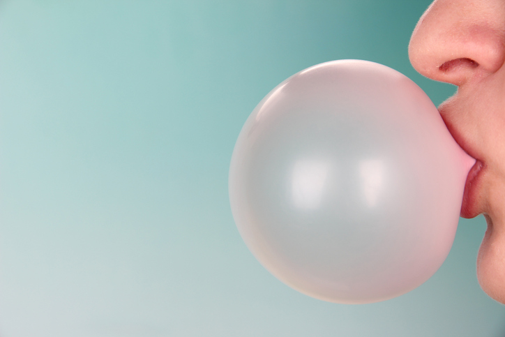 woman blowing a bubble with bright background